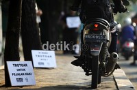 Mereka juga membawa poster-poster yang berisi imbauan kepada pengendara motor agar tidak menorobos trotoar.