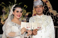 Dengan bahagia padangan itu menunjukkan buku nikah mereka.(Herianto Batubara/detikcom)