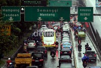 Kendaraan bermotor dan mobil berhati-hati saat hujan deras mengguyur lintasan jalan.
