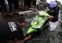Seorang warga membantu pengendara yang mogok.