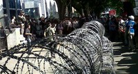 Polisi memasang kawat berduri untuk menghadang massa.