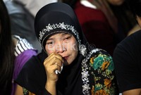 Salah satu keluarga korban mengusap air mata yang membasahi pipinya.