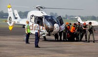 Beberapa petugas tampak membawa kantong jenazah dari pesawat menuju mobil ambulance.