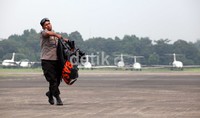 Seorang polisi berlari sambil mengangkat sebuah kantong jenazah ketika proses evakuasi kecelakaan pesawat Sukhoi Super Jet 100 di Bandara Halim Perdanakusuma