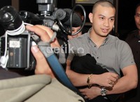 Sazni nampak mengenakan kemeja abu-abu dipadu dengan jaket hitam dan celana panjang berwarna senada. Herianto Batubara/detikhot