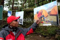 Sabar menunjuk sebuah foto yang memperlihatkan persiapan yang harus dia lakukan sebelum mendaki puncak Elbrus. Muchus Budi Rahayu/detikNews.