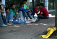 Salah satu sepatu bot dari buruh bangunan diletakkan dipendestrian jalan. Para buruh pekerja bagunan diberikan waktu istirahat selama satu jam.