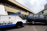Sebuah mobil Toyota Kijang milik pelayat diderek petugas.