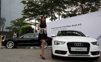 Seorang model berpose dengan Audi A5 Coupe.