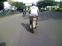 Seorang petugas polisi mengendarai motor tanpa pelat nomor. Belum diketahui apakah motor ini motor sitaan atau tidak (Ikhsan Nurrochiem).