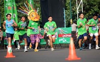 Seorang peserta yang mengenakan topeng ondel-ondel terus berlari mengejar peserta lainnya.
