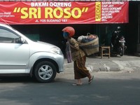 Entah lupa mencopot setelah mengendarai motor, atau memang ibu ini tetap waspada selama di perjalanan. (Foto Irwan Yulianto)