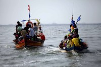 Para nelayan memadati perahu-perahu kayu untuk melepas sesaji ke tengah laut.