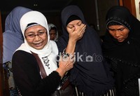 Nurlaila dipapah anggota keluarga lainnya.