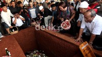 Keluarga dan pelayat menabur bunga ke makam Didik Nur Yusuf.