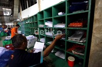 Seorang petugas menata surat-surat yang akan dikirim.