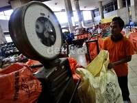 Seorang petugas menimbang paket kiriman di kantor Pos Pasar Baru, Jakarta.