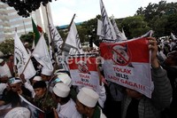Beberapa pendemo membentangkan poster penolakan.