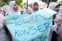 Siswa SMA memegang poster menolak kedatangan Lady Gaga. Mereka tidak rela Indonesia didatangi ibu para monster Lady Gaga.