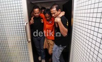 Hendra dipapah petugas aat gelar barang bukti di Mapolda Metro Jaya, Minggu (27/5/2012).  Kepala Subdit Resmob Polda Metro Jaya AKBP Herry Heryawan mengatakan, barang bukti tersebut disita dari rumah kontrakan tersangka di Kramat Jati, Jakarta Timur pada Sabtu (26/5) malam.
