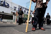 Puluhan orang mencoba bertahan dengan membawa pentungan di kampus Trisakti Grogol, Jakarta.