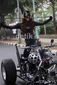 Dengan berpakaian cat women lengkap dengan pecutannya, DP berpose seksi di atas motornya.