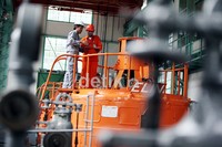Dua petugas PLTA Kracak, tengah mengontrol generator pembangkit listrik, di PLTA Kracak, Bogor, Jawa Barat, Rabu (30/05).