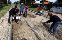 Beberapa pekerja mengeruk batu yang menutupi rel kereta api. Penutupan perlintasan kereta api liar tersebut untuk menghindari terjadinya insiden tertabraknya kendaraan oleh kereta.