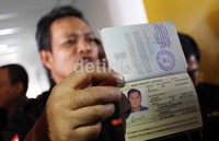 Petugas menunjukkan pasport salah satu tersangka.