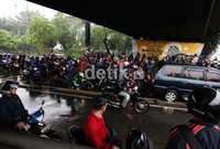 Kendaraan mobil maupun bus yang melintasi jalan tersebut agak sedikit tersendat karena separuh badan jalan tertutup oleh kendaraan motor yang parkir di bawah jembatan tersebut.
