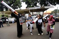 Dalam aksi tersebut, mereka membawa beberapa batang rokok berukuran besar.