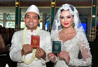 Catherine Wilson dan Achmad Muckhlas Arofat memamerkan buku nikah mereka.