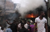 Tampak api berkobar membakar bangunan dan puing pesawat. REUTERS/Akintunde Akinleye.
