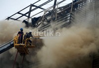 Petugas pemadam kebakaran kota Makassar berjibaku menyemprotkan busa ke lantai 5 hotel yang terbakar. Muhammad Nur Abdurrahman/detikNews.