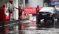 Meski tergenang, aktivitas di SPBU tersebut tetap berjalan seperti biasa. Petugas tetap melayani kendaraan yang akan mengisi bensin.