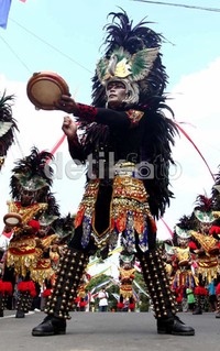 Para penari tampil dengan kostum yang unik. Setiap penari memakai mahkota dari bulu dan pakaian warna warni.