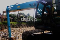 Dengan bantuan alat berat petugas mengangkut sampah dari sungai. Agung Pambudhy/detikcom.