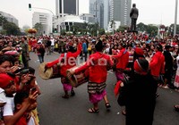 Masyarakat Jakarta antusias menunggu karnaval di perempatan patung kuda. Tampak patung MH Thamrin yang baru diresmikan beberapa waktu lalu, memunggungi kamera.
