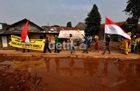 Dalam aksinya, warga membawa keranda mayat dan bendera kuning.