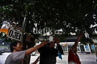Para tukang ojek menggantung kantong plastik yang berisi cairan warna-warni di pohon di sekitar tempat mereka mangkal.