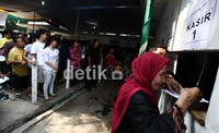 Warga dari berbagai daerah di Jakarta ini menunggu pembagian dari loket. Usahanya antre berbuah gaji Rp 250 ribu.