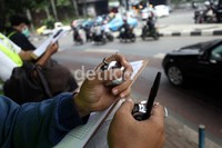 Dengan menggunakan alat penghitung, petugas terus memantau kendaraan yang melintas di Jalan Dukuh Atas, Jakarta.