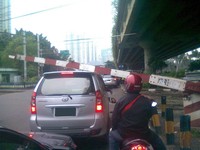 Akibat ingin menerobos perlintasan kereta api Karet Bivak, mobil ini terkena palang pintu pada kap atasnya. (Foto Cahyo Wibowo)