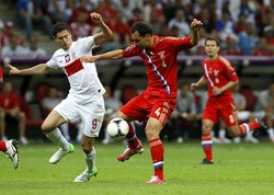 Robert Lewandowski berebut bola dengan Sergei Ignashevich. Hingga peluit panjang ditiup, kedudukan tetap 1-1. Dengan hasil tersebut Rusia masih memimpin klasemen sementara dengan koleksi empat poin dari dua pertandingan. Polandia menghuni peringkat ketiga dengan dua poin. Reuters/Pascal Lauener