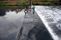 Tiga orang anak tersebut tidak menghiraukan dampak dari bermain air tersebut. Selain mengandung limbah arena bermain anak tersebut sangat berbahaya.