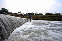 Tiga orang anak tersebut tampak asyik bermain di aliran sungai Banjir Kanal Timur. Minimnya lahan bermain membuat sejumlah anak menjadikan aliran sungai ini sebagai lahan bermain.