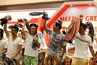 Mereka meneriakkan yel-yel mendukung tim Indonesia sambil mengoyang sarung yang mereka bawa.