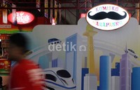 Seorang pengunjung PRJ melintas di depan gambar tersebut. Belum diketahui alasan dan maksud slogan itu.