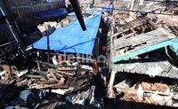 Warga korban kebakaran mendirikan tenda di puing-puing rumah mereka yang hangus terbakar.