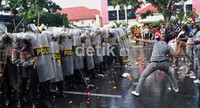 Anggota polisi berakting layaknya seorang demonstran yang melempari pasukan huru hara yang mengawal aksi unjuk rasa. Muhammad Nur Abdurrahman/detikcom.
